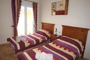 twee bedden in een kamer met een raam bij Bungalow Aldea del Mar in Els Poblets +22 foto's