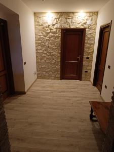 einen Flur mit einer Steinmauer und einer Holztür in der Unterkunft Il Casale Di Ginetto in Cascia