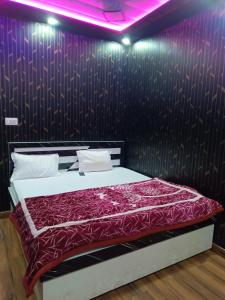 een slaapkamer met een bed met een paarse muur bij Shri Ram Residency 5 mint walking from Shri Ram Janmabhoomi main temple in Ayodhya