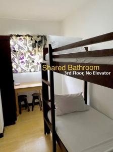 a room with two bunk beds and a desk at Kampotel Davao in Davao City