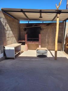 a garage with a brick wall and a tire under a roof at Cabaña Oasis de Pica in Pica