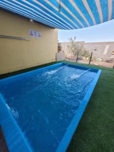 a large blue swimming pool with a roof at Cabaña Oasis de Pica in Pica