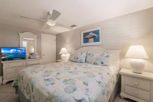 1 dormitorio con 1 cama y TV de pantalla plana en Villa 42 - Aloha Kai Vacation Villas, en Siesta Key