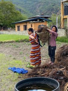 two women are standing next to a bucket of water at Amas Village Lodge in Paro