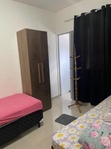 1 dormitorio con 1 cama y armario de madera en Pousada Aeroporto Viracopos Campinas, en Viracopos