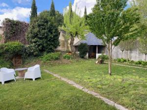 um quintal com uma mesa e cadeiras e uma árvore em Clos des Chardons - Le Jardin em Saint-Aignan
