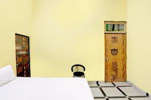 a room with a bed and a wooden door at OYO J.M.D Restaurant &rooms in Jhājhar