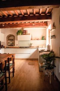 una cucina con armadi bianchi e tavolo in legno di Social Garden - Sharing Room a Calci