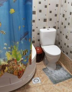 La salle de bains est pourvue de toilettes et d'un rideau de douche. dans l'établissement Gavhar House, à Khiva