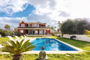 a house with a swimming pool in front of a house at Red House Rooms in Llucmajor