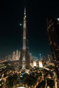 a tall skyscraper in a city at night at Burj Khalifa & Fountain Views, Exclusive Apartment in Burj Vista Building in Dubai