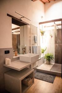 bagno con lavandino e grande specchio di Social Garden - Sharing Room a Calci