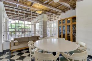 una sala da pranzo con tavolo e sedie bianchi di Pool view 2BHK 5 min to Airport a Vasco da Gama Altre 26 foto