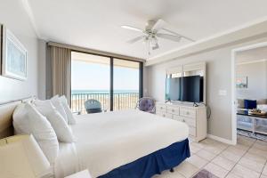 a bedroom with a large bed and a television at Emerald Surf 102 in Navarre