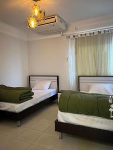 Cette chambre comprend deux lits et un lustre. dans l'établissement شقة فاخرة مطلة على نهر النيل, au Caire 21 autres photos