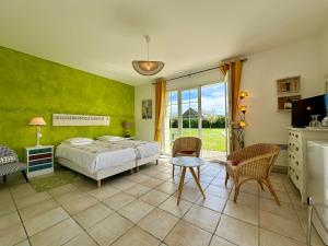 1 dormitorio con 1 cama, mesa y sillas en Le Clos des 4 Saisons, en La Rochepot
