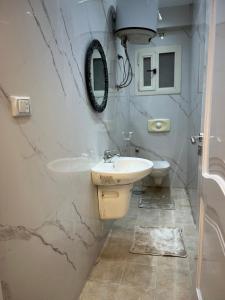 une salle de bain avec un lavabo et des toilettes dans l'établissement شقة فاخرة مطلة على نهر النيل, au Caire