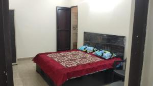 - une chambre avec un lit et une couette rouge dans l'établissement The Wooden Cottage Sakar, à Mukteswar