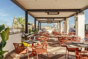 un restaurant avec des tables et des chaises sur un balcon dans l'établissement Vincci La Rabida, à Séville