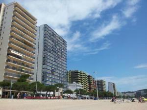 ein großes Gebäude am Strand neben einem Strand in der Unterkunft Apartamento Coquette a 50 metros de la playa in Platja  d'Aro