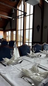 una mesa con manteles blancos y copas de vino. en Sirevåg Konferansehotell AS en Sirevåg