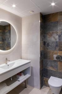 a bathroom with a sink and a toilet and a mirror at Hotel Pimar & Spa in Blanes