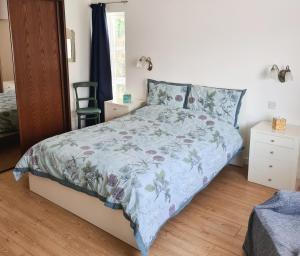 a bedroom with a bed with a blue comforter at Nara Seaside Retreat in Cultra