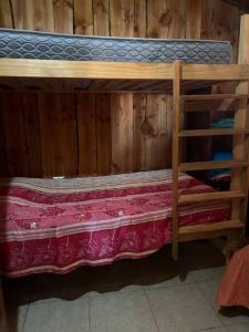 ein Etagenbett aus Holz mit einer rosa Decke darauf in der Unterkunft •Cabañas Patagonia• in Puerto Montt