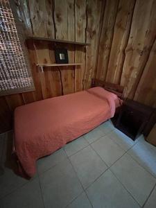 Un dormitorio con una cama con una manta roja. en •Cabañas Patagonia•, en Puerto Montt