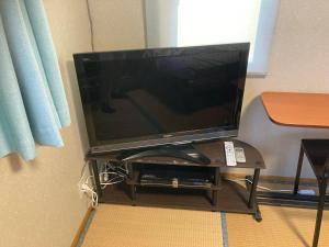 telewizor z płaskim ekranem siedzący na stole w obiekcie やまおう　宿＆カフェ w mieście Nikaho