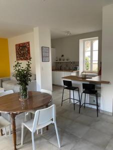 uma cozinha e sala de estar com mesa e cadeiras em Clos des Chardons - Le Jardin em Saint-Aignan
