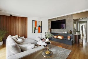 uma sala de estar com um sofá e uma lareira em Ecrin de luxe à la Tour Eiffel em Paris