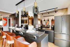 uma cozinha com um longo balcão com cadeiras e electrodomésticos em Ecrin de luxe à la Tour Eiffel em Paris