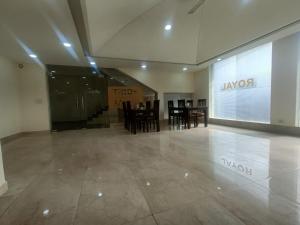 a lobby with tables and chairs and a large window at Hotel Ronit Royal - New Delhi Airport in New Delhi