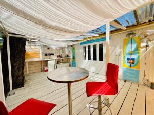 a room with a table and two red chairs at Bungalow avec piscine in Antibes