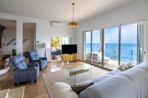 uma sala de estar com vista para o oceano em Villa Can Biel Canyamel by Slow Villas em Canyamel
