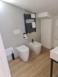 a white bathroom with a toilet and a sink at Hotel Miratorre superior in Pisa