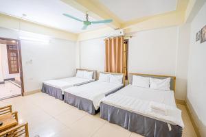 a bedroom with two beds and a ceiling fan at Sen Vàng Hotel in Sầm Sơn