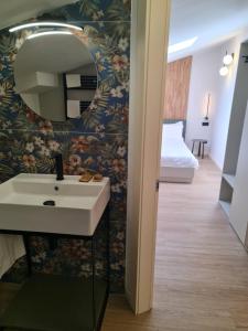 uma casa de banho com um lavatório e um espelho na parede em Hotel Miratorre superior em Pisa