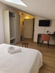 sypialnia z białym łóżkiem, biurkiem i krzesłem w obiekcie Hotel Miratorre superior w Pizie