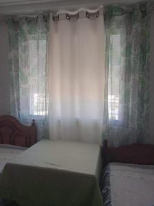 a bedroom with a bed and a window with curtains at Dar Momo in Nabeul