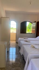 a room with four beds and a flat screen tv at Pousada da Ilha ECO LAZER in Una