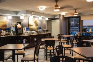 um restaurante com mesas e cadeiras e um bar em Best Western Plus Cypress Creek em Biloxi