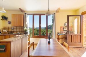 a kitchen with a wooden table and a large window at Cal Malla petit in Artés
