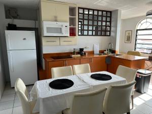 聖胡安的住宿－10BR, 6BA Compound Perfect for Large Groups, Near Ocean Park Beach，厨房配有白色桌子和白色冰箱。