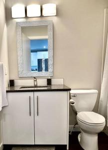 uma casa de banho com um WC branco e um espelho. em Modern & Luxurious Private Suite in Regina em Regina