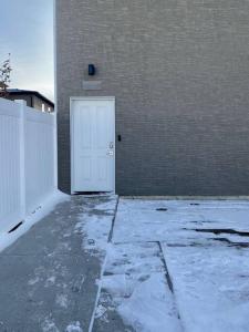 una puerta blanca en el lateral de un edificio en Modern & Luxurious Private Suite in Regina, en Regina