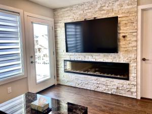 ein Wohnzimmer mit einem Kamin und einem Flachbild-TV in der Unterkunft Modern & Luxurious Private Suite in Regina in Regina