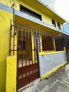 un bâtiment jaune avec une porte devant lui dans l'établissement 10BR, 6BA Compound Perfect for Large Groups, Near Ocean Park Beach, à San Juan