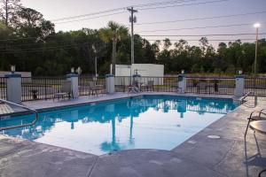 uma piscina com água azul em frente a uma cerca em Best Western Plus Cypress Creek em Biloxi
